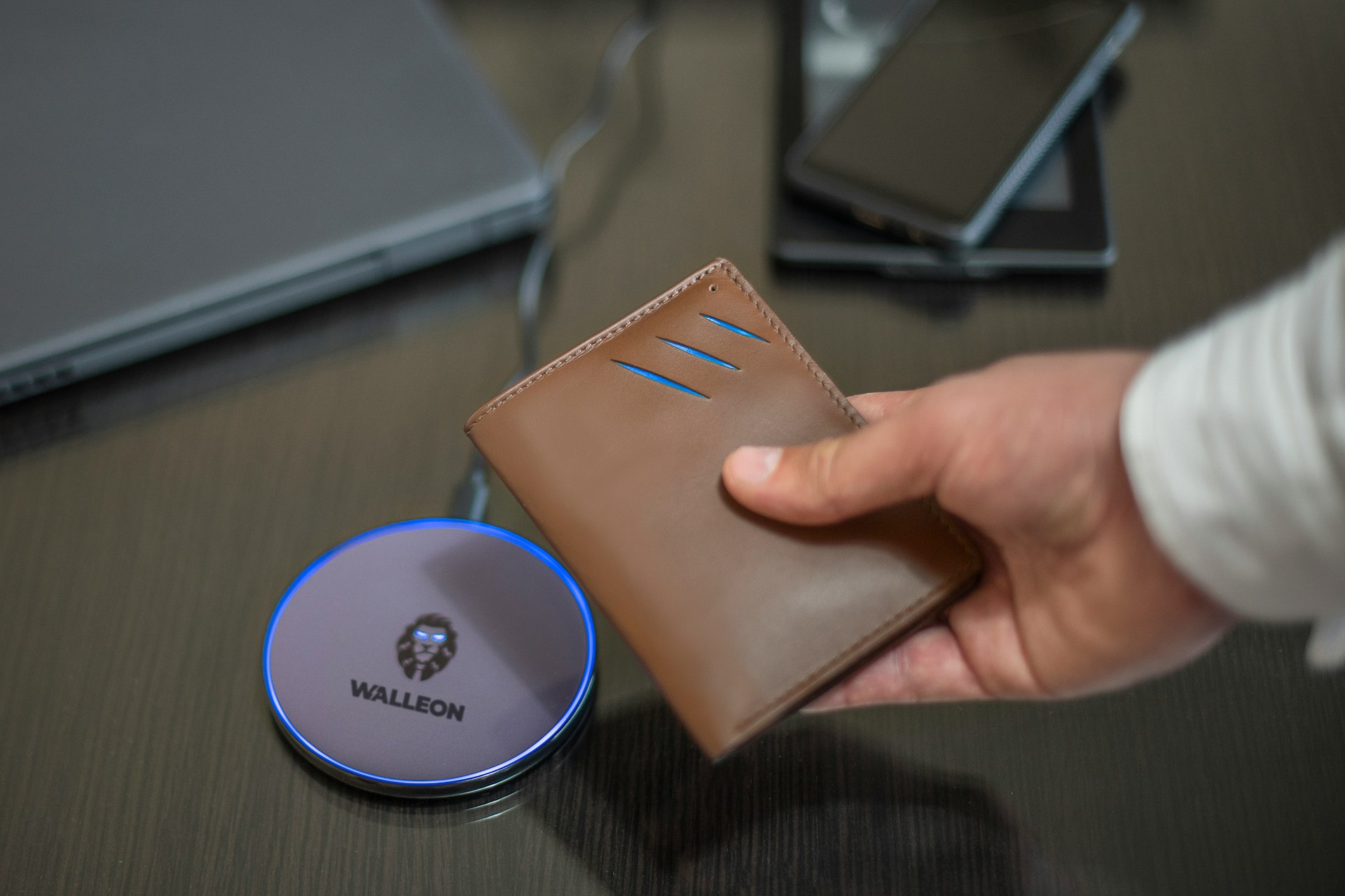a person holding a wallet next to a laptop